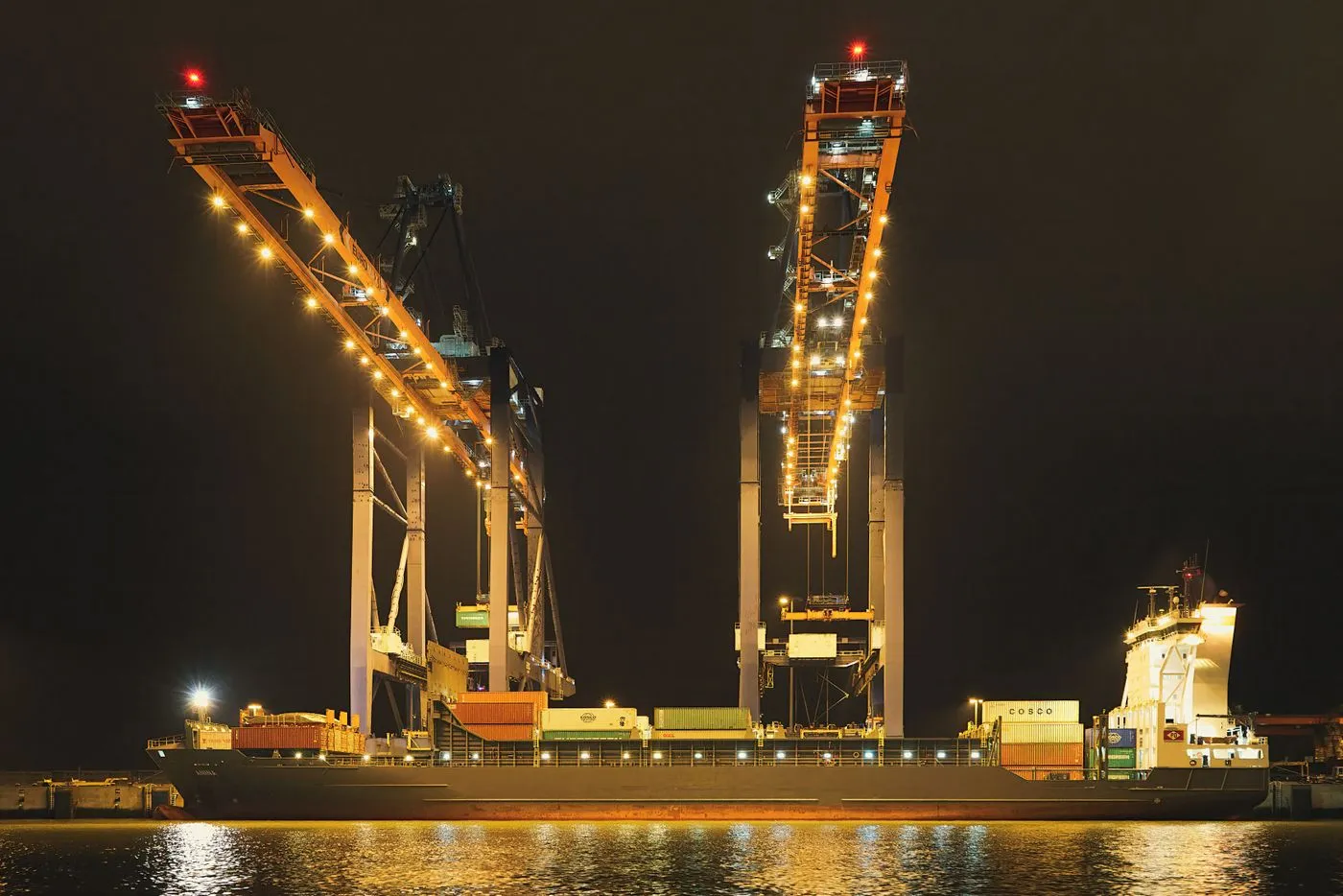 Ship-to-shore cranes working a container vessel at night